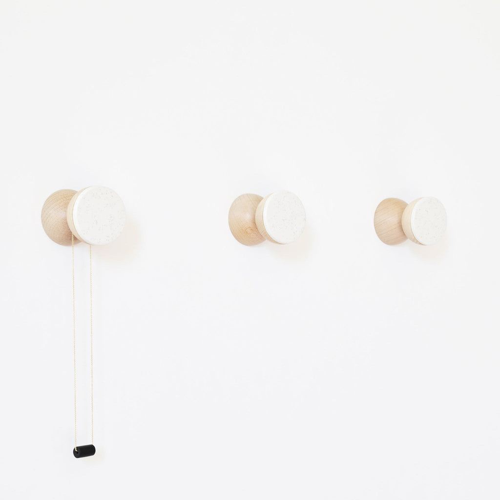 3. Studio image of three 5mm Paper Beech Wood & Ceramic Wall Hooks in white sand, showing geometric design