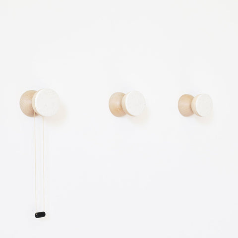 3. Studio image of three 5mm Paper Beech Wood & Ceramic Wall Hooks in white sand, showing geometric design