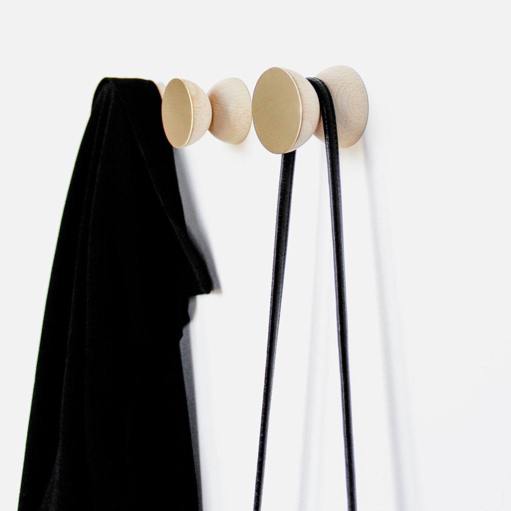 1. Beech wood and brass wall hooks by 5mm Paper, used for hanging coats and bags, shown in lifestyle setting