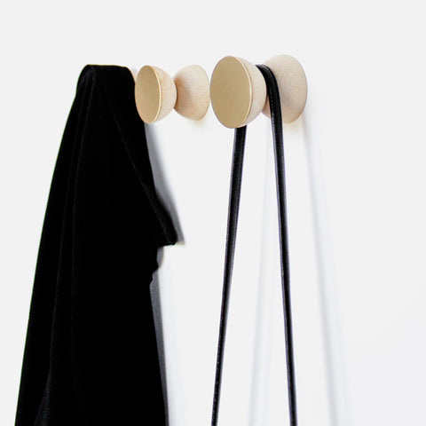 1. Beech wood and brass wall hooks by 5mm Paper, used for hanging coats and bags, shown in lifestyle setting