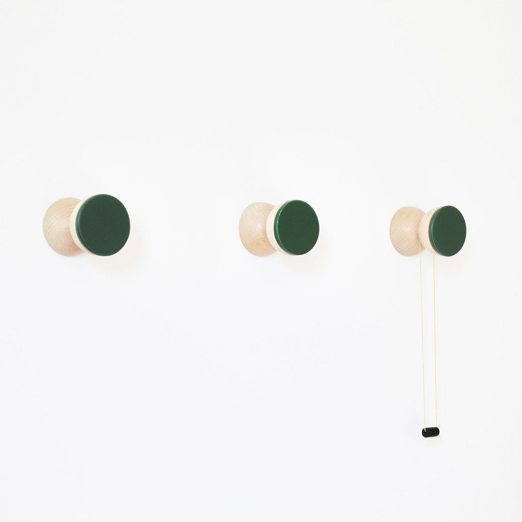 1. Set of three Beech Wood & Ceramic Wall Hooks in dark green by 5mm Paper, mounted on a white wall