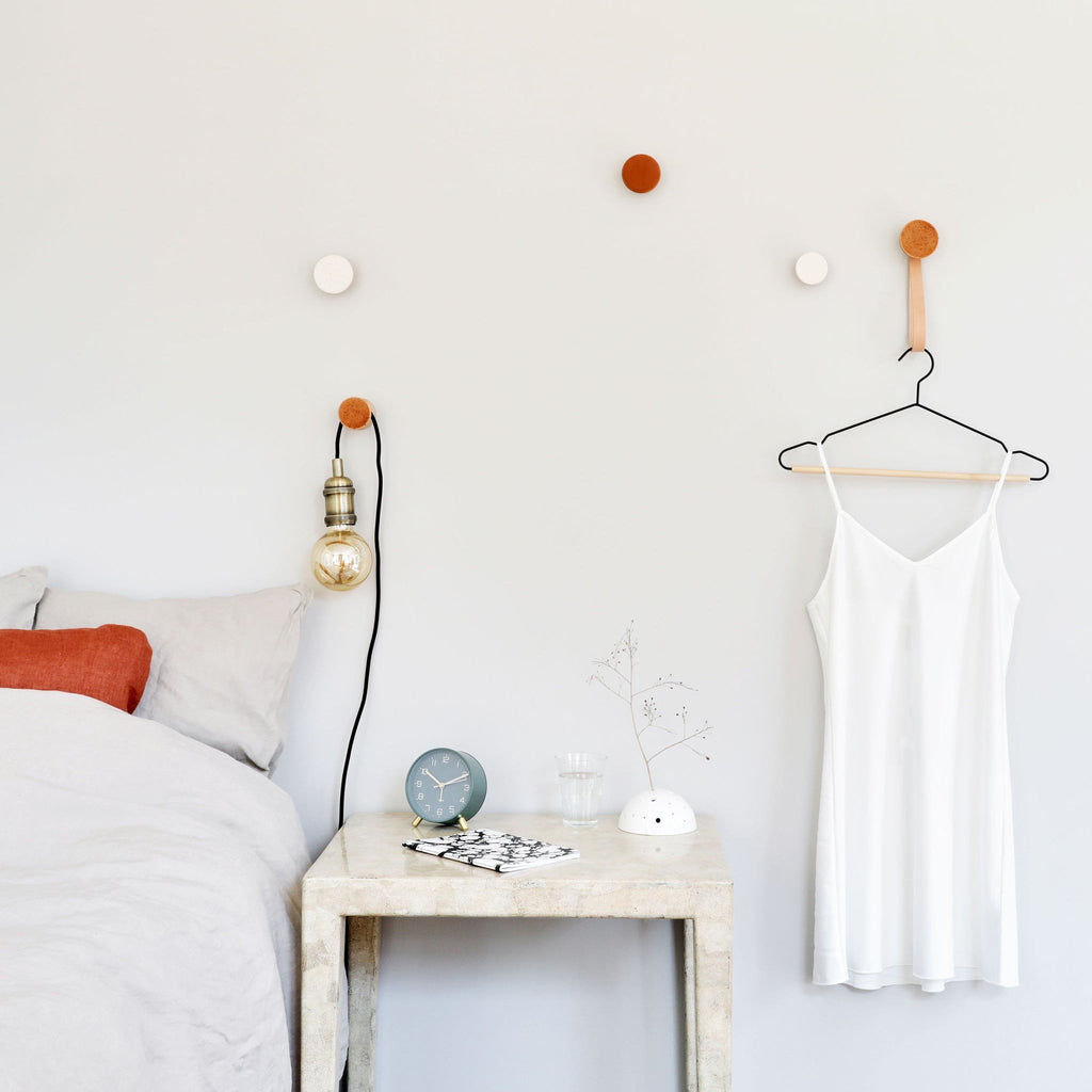 1. Lifestyle image of Beech Wood & Ceramic Wall Hook in terracotta orange specks, used as a coat hook in a modern bedroom setting