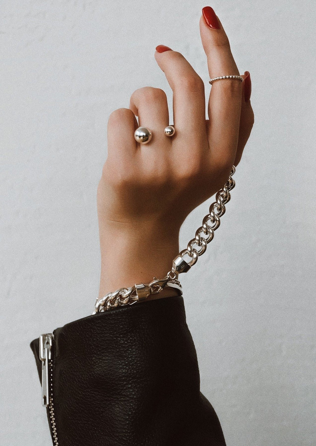 4. Woman's hand adorned with NO MORE Big Bomb Multisize Ring in silver, paired with a chunky bracelet, showcasing elegant style