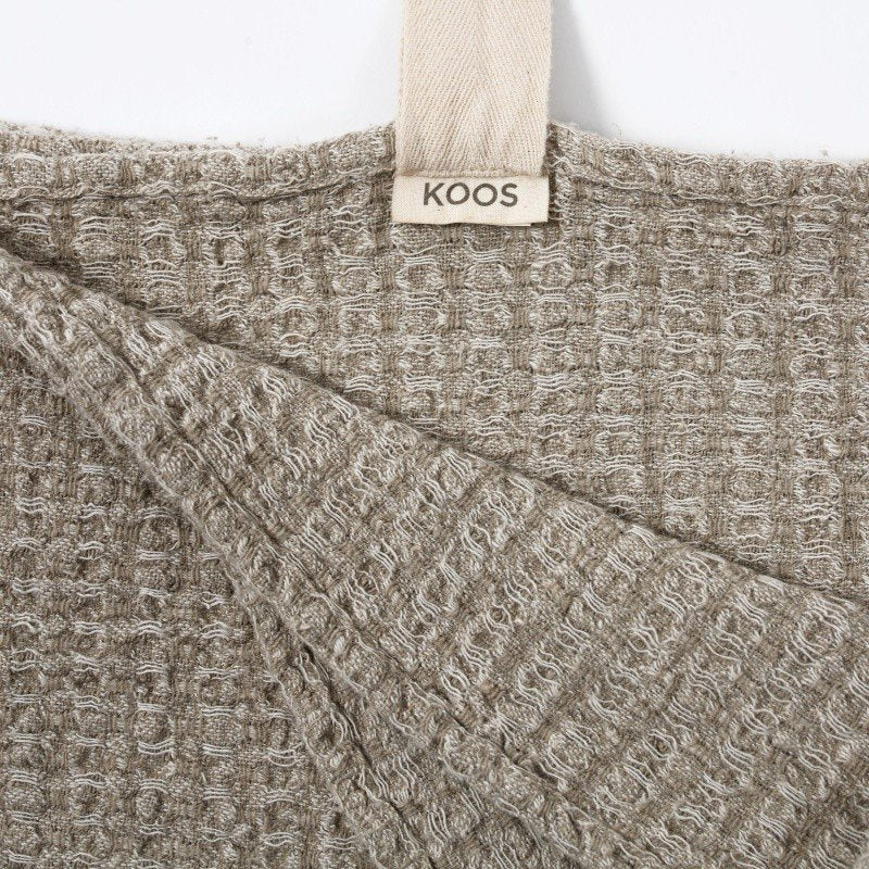 2. Close-up of grey textured linen towel with KOOSdisain label and cotton hanger