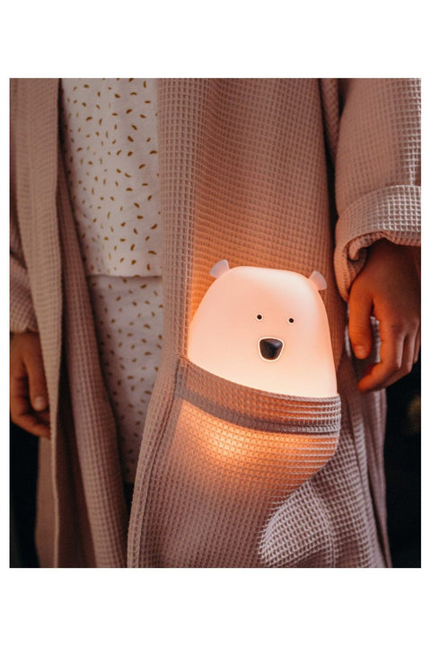 3. Pink teddy bear-shaped lamp in child's robe pocket, warm glow