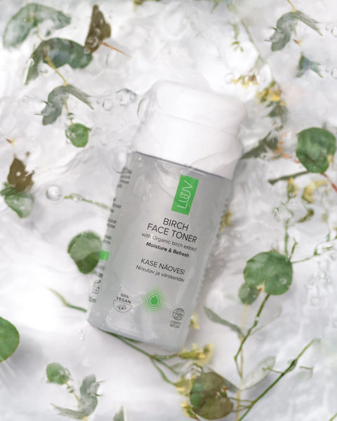 1. LUUV Birch Face Toner bottle with organic birch extract on a watery background with green leaves