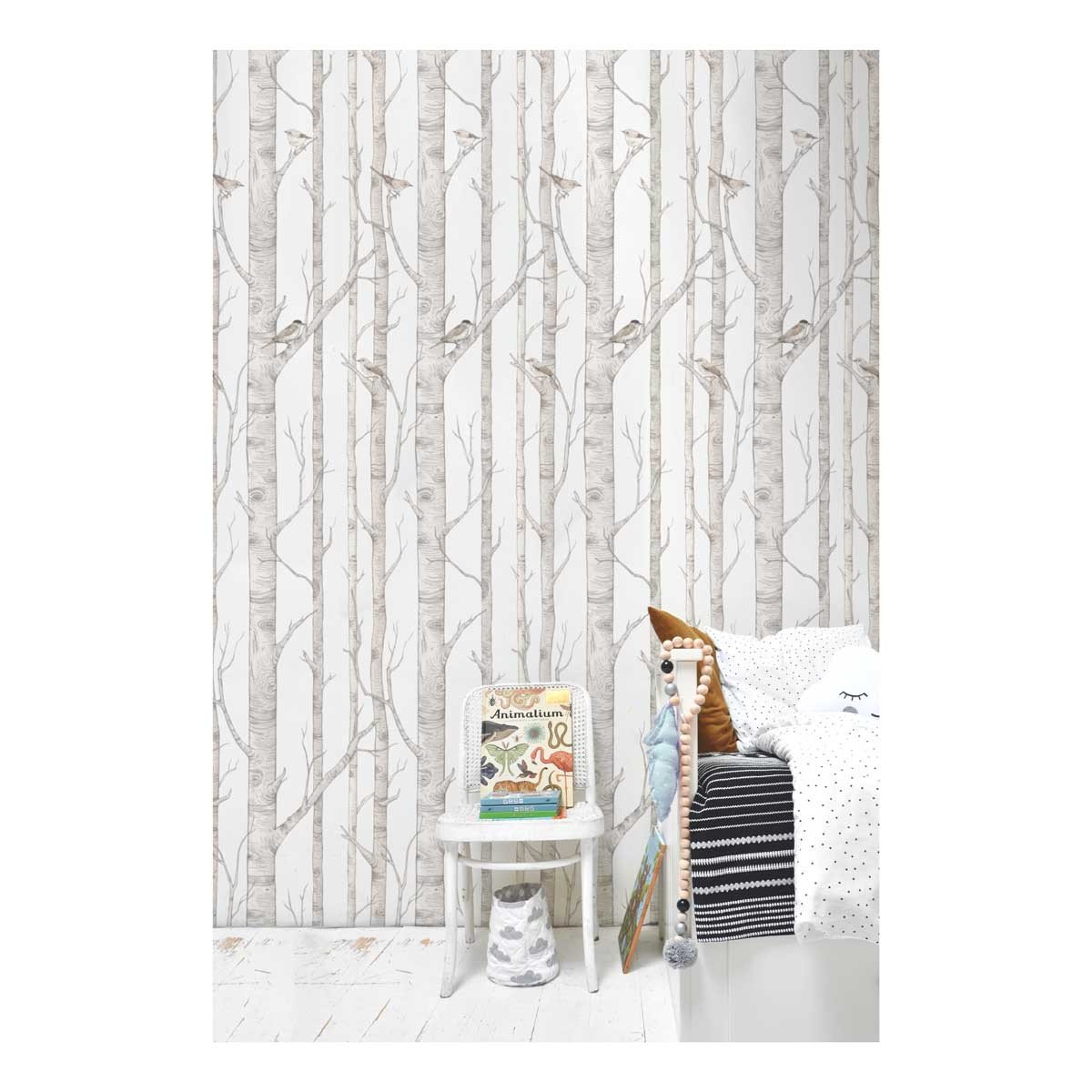 2. Birch forest wallpaper in a child's bedroom with birch trees and birds, next to a white side table with books and a bed with patterned pillows