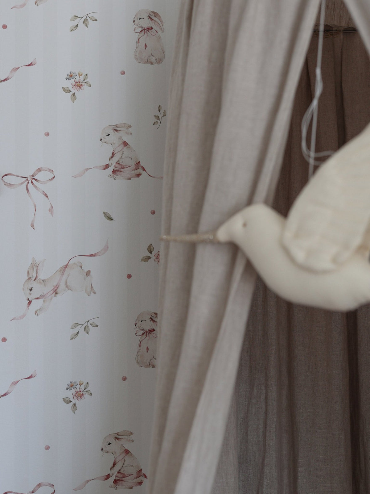 3. Close-up of pink rabbits on stripes wallpaper with beige curtain and bird decor