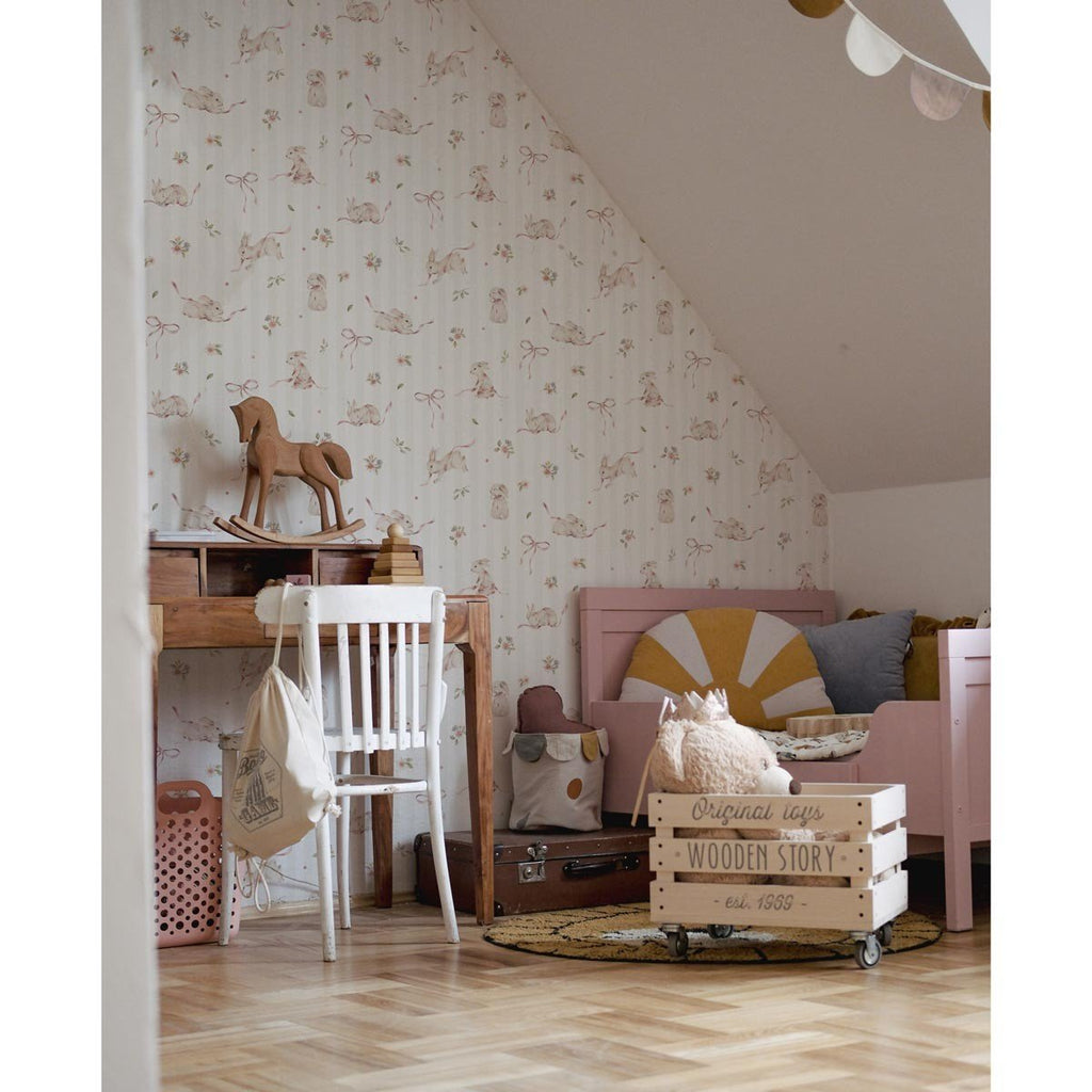 1. Playroom with pink rabbits on stripes wallpaper, wooden toys, and pink furniture