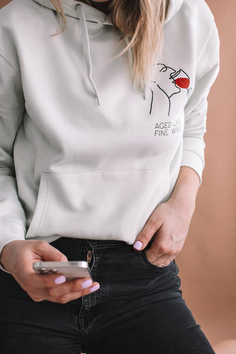 4. Close-up of Black Giraffe Brand 'Aged Like Fine Wine' hoodie in light green, highlighting design and text