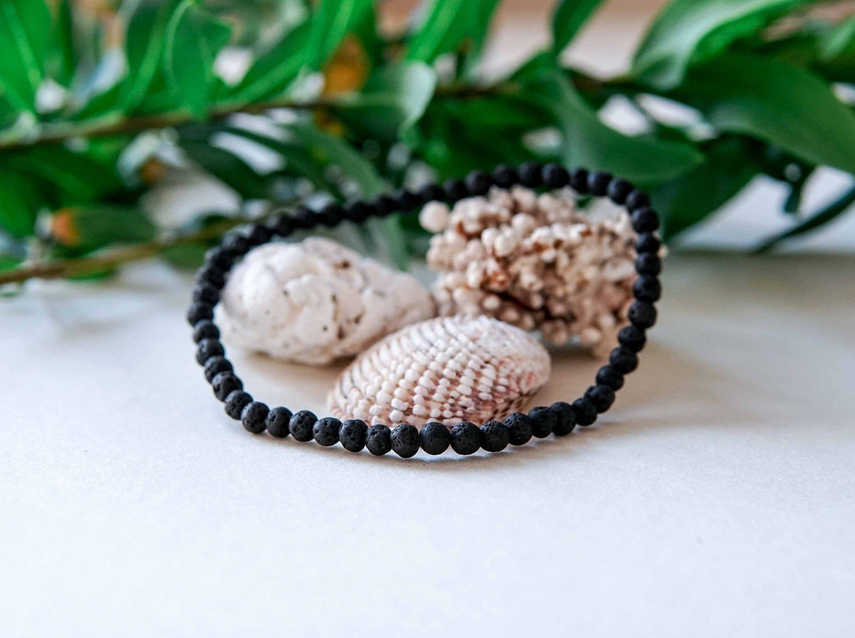 4. Close-up of men's Black Lava Anklet by Canary Lava with seashells, emphasizing natural materials