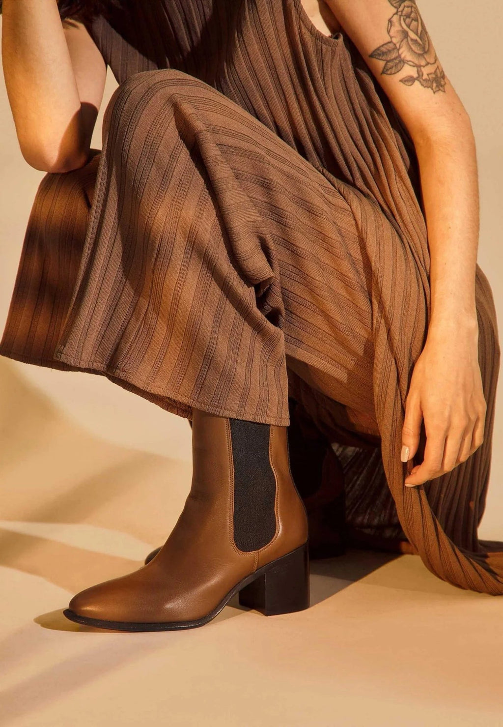 4. Close-up of brown leather Chelsea boot with black elastic panel, worn with brown pleated pants