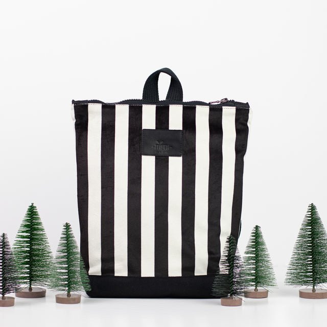 5. Muni black and white striped kids backpack in studio with decorative trees