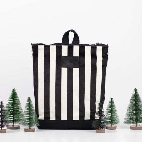 5. Muni black and white striped kids backpack in studio with decorative trees