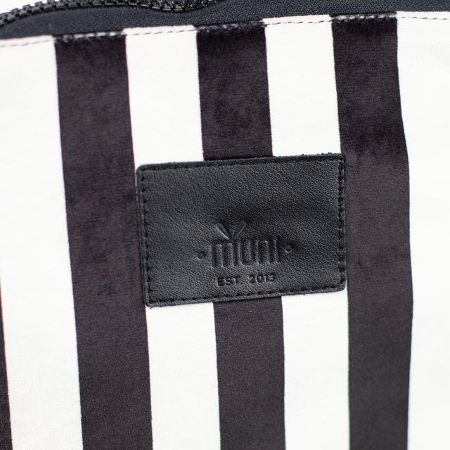 7. Close-up of Muni logo on black and white striped kids backpack