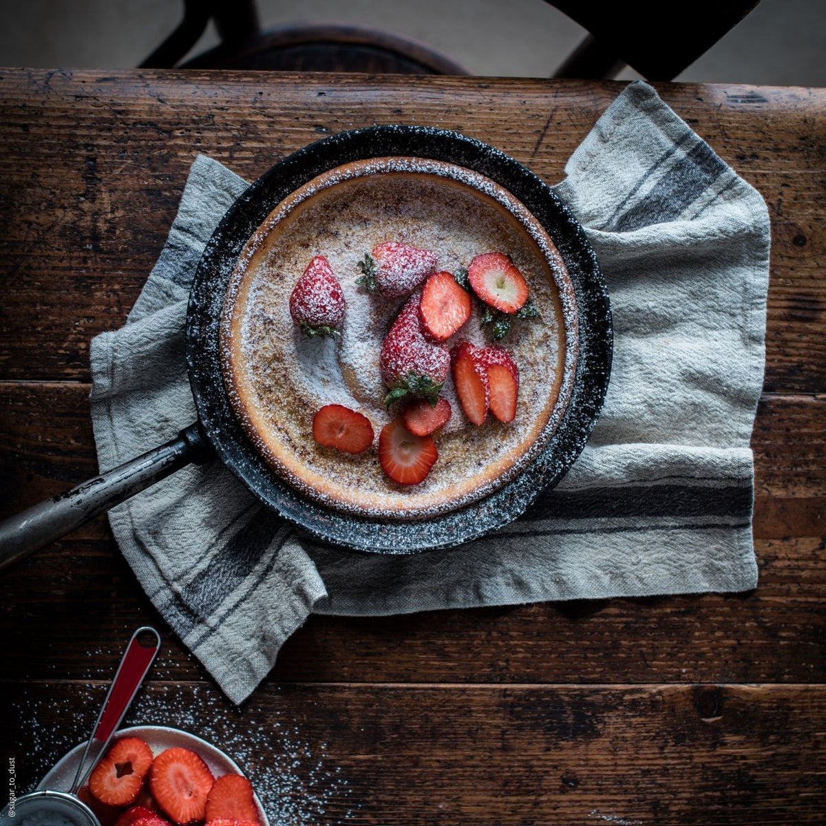 4. Beige linen towel with blue stripes under skillet with strawberries on wooden table