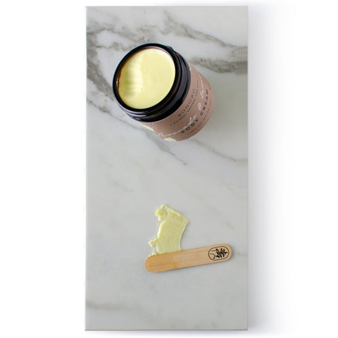 4. Open jar of BONOBO Avocado and Lemon Body Cream with cream texture and applicator, close-up