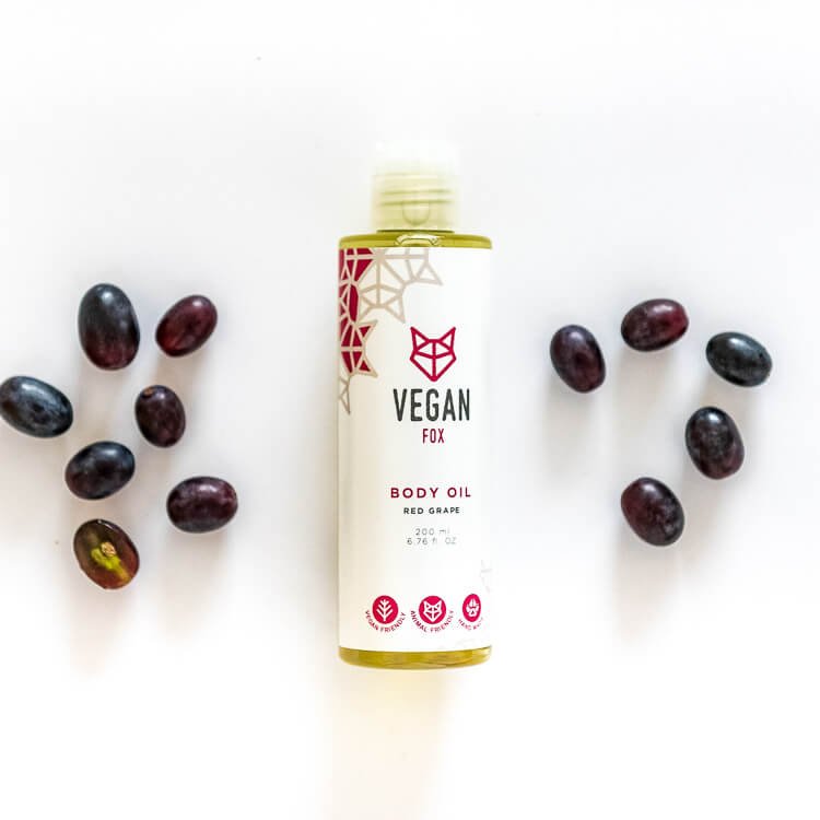 2. Vegan Fox Red Grape Body Oil, 200 ml, with scattered red grapes in a flat lay