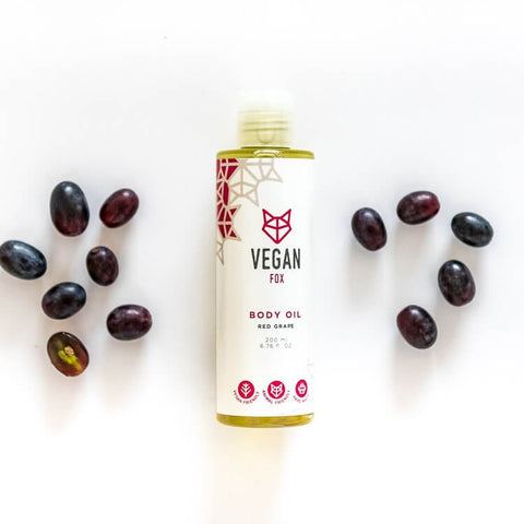 2. Vegan Fox Red Grape Body Oil, 200 ml, with scattered red grapes in a flat lay