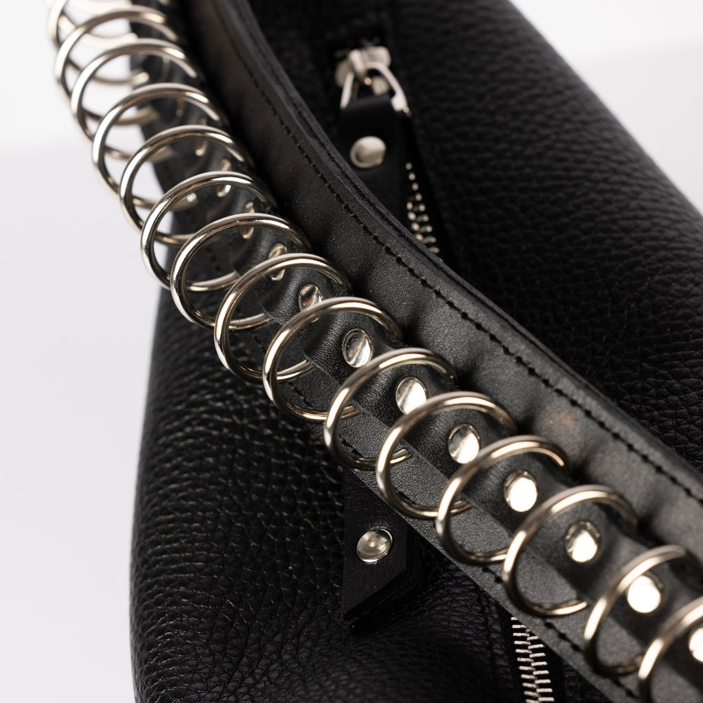 3. Close-up of metal chain detail on black leather strap of PYKOK Handbag Bona