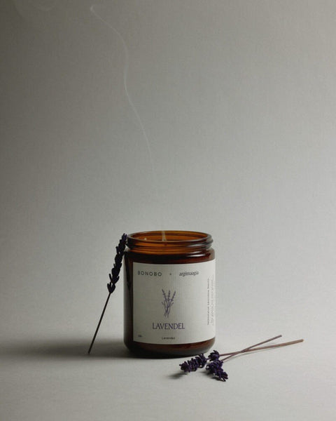 1. Bonobo lavender scented candle in amber glass jar with lavender sprigs on neutral background
