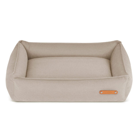 2. Beige Bosca dog bed by Labbvenn with high sides and leather logo tag, shown in studio setting highlighting modern design and durable materials