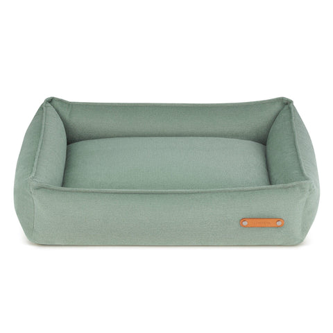 2. Soft teal dog bed with high sides and leather logo tag on front, designed by Labbvenn, shown in studio setting highlighting modern design and durable materials