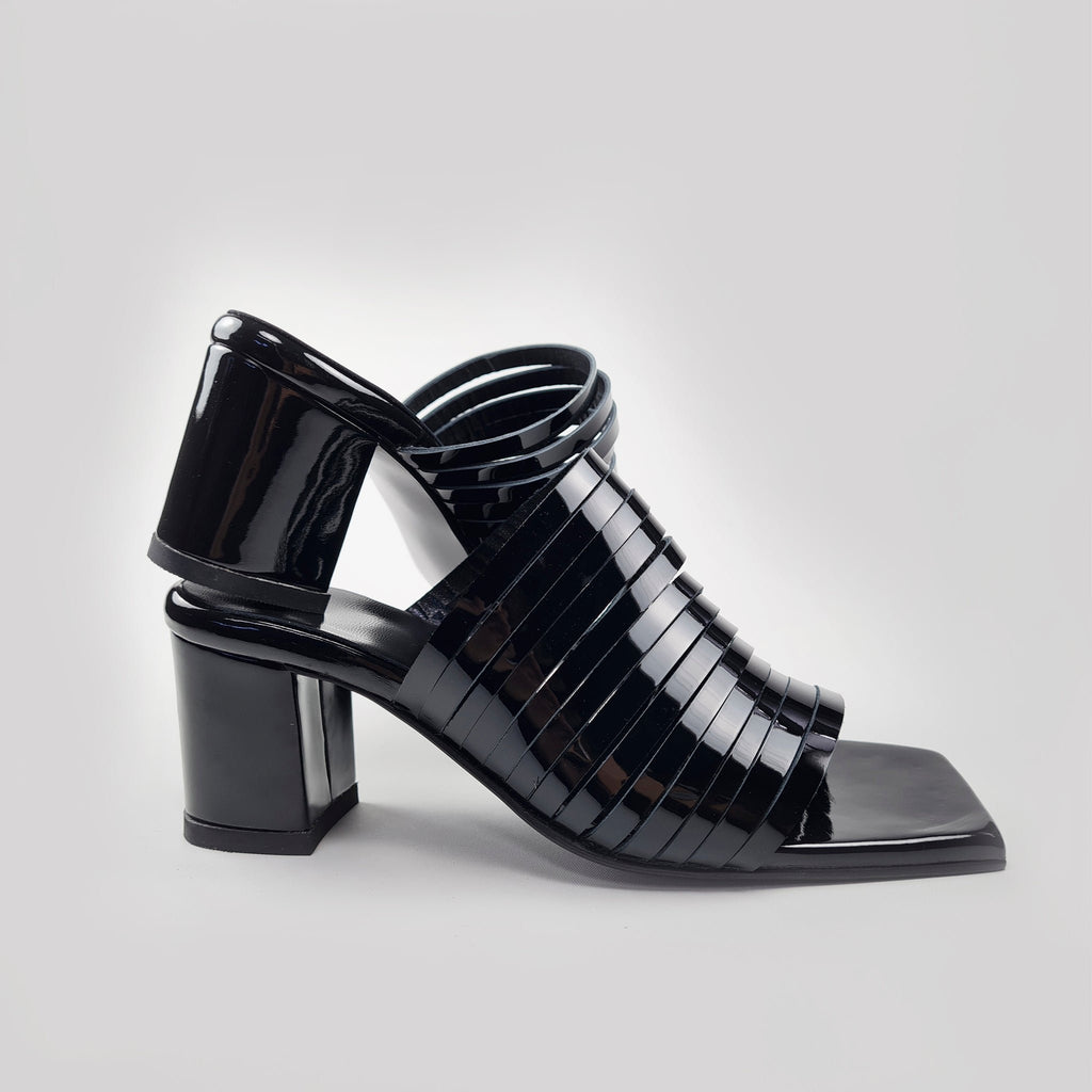 5. Side profile of women's black patent leather sandals with squared toe and block heel