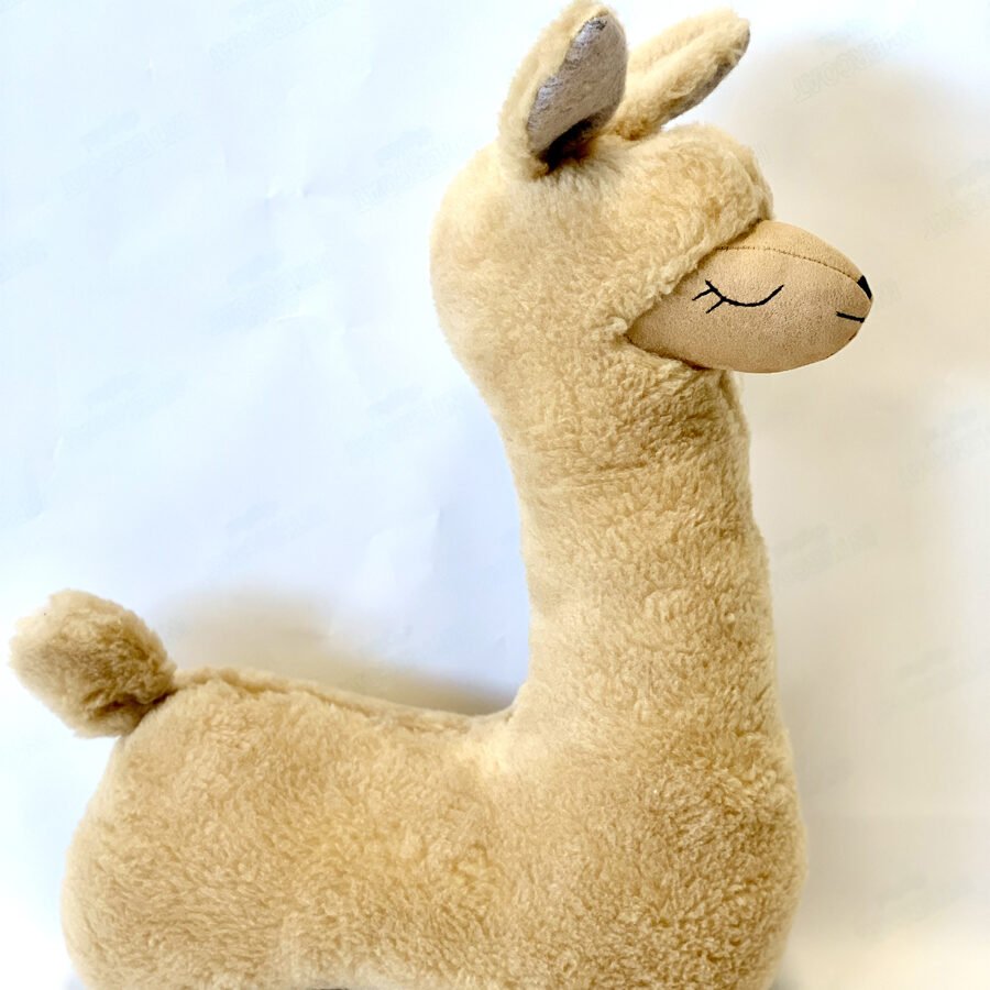 3. Side view of rusty brown alpaca soft toy-pillow showing plush texture and closed eyes