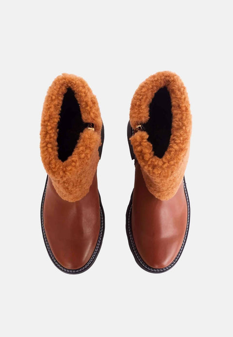 3. Top view of brown leather ankle boots with shearling lining on white background