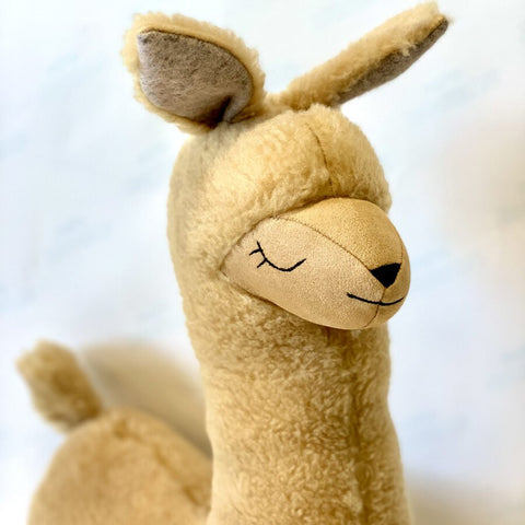 2. Studio shot of handmade rusty brown alpaca soft toy-pillow with closed eyes and soft texture