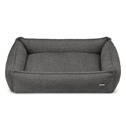 2. Anthracite boucle dog bed by Labbvenn with high sides for stability, shown in studio setting highlighting texture and design, removable cover for easy maintenance, hypoallergenic and durable materials.