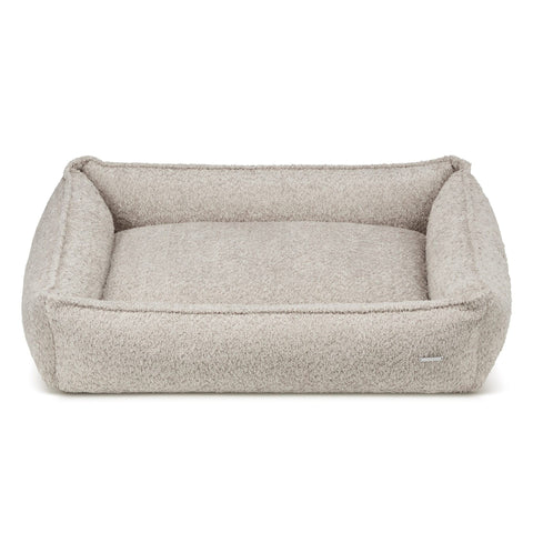 2. Light beige boucle dog bed by Labbvenn with high sides for stability, shown in studio setting highlighting texture and design