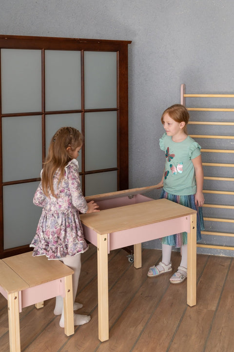 1. Two girls playing with smart storage table and chair set in a playroom, one sitting and one standing