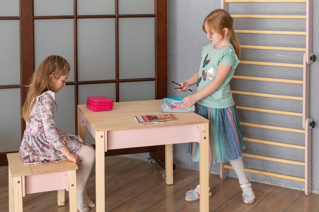 1. Two girls playing with smart storage table and chair set in a playroom, one sitting and one standing