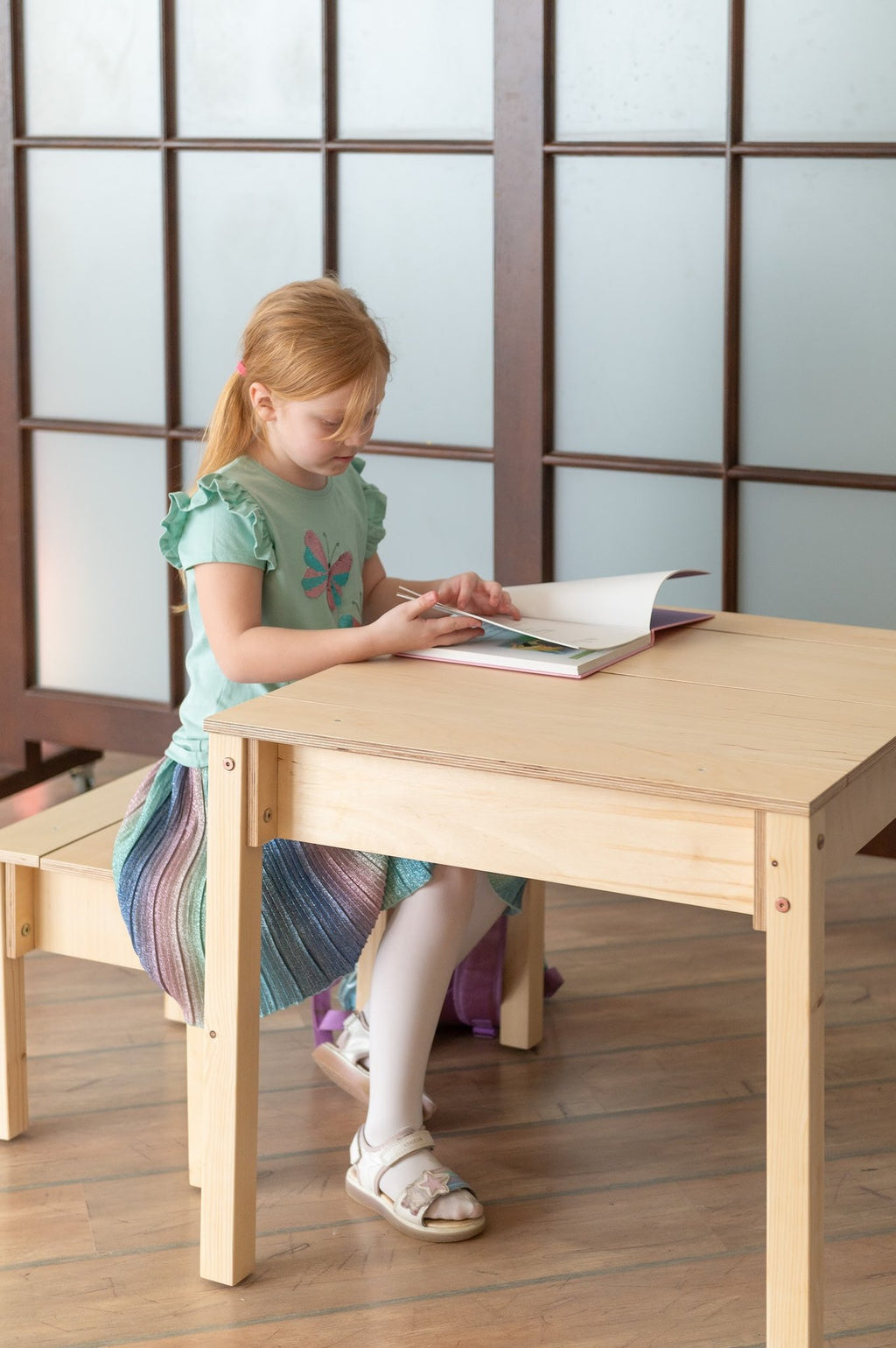 1. Girl reading at smart storage table and chair set in a playroom