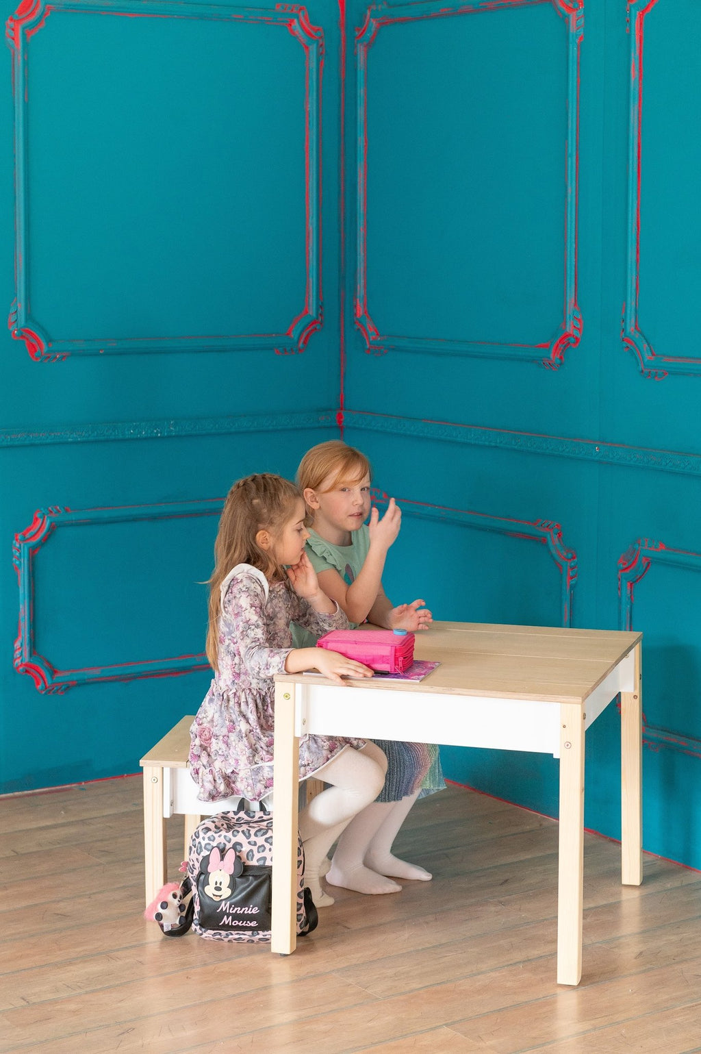 1. Girl organizing items in smart storage table and chair set in a playroom