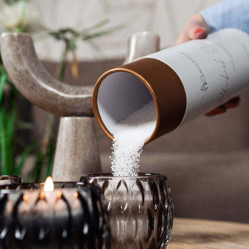 6. Pouring Candledust powdered candle into a glass holder, with lit candle in the foreground
