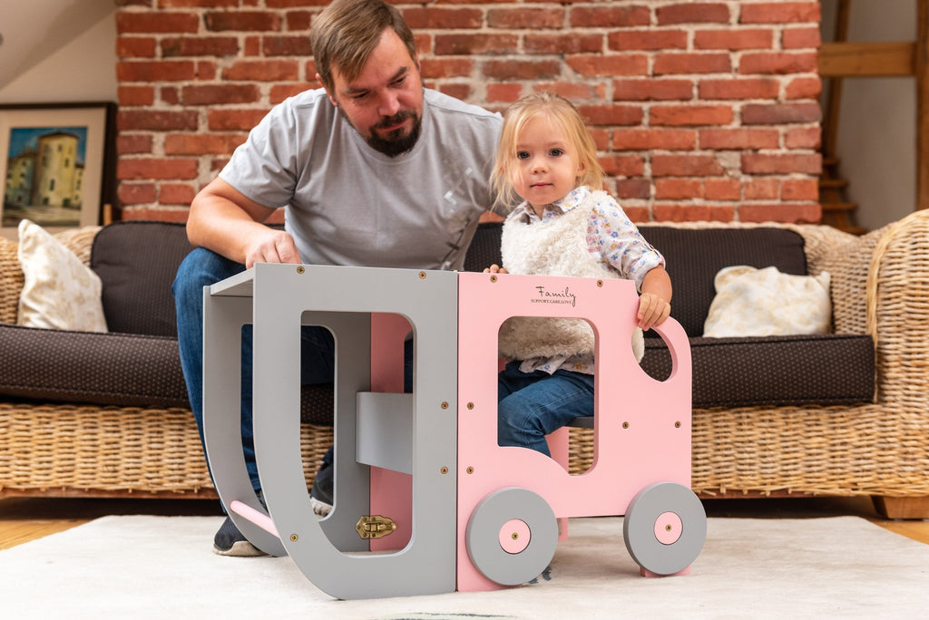 1. Man and child playing with pink and grey Montessori learning table in living room