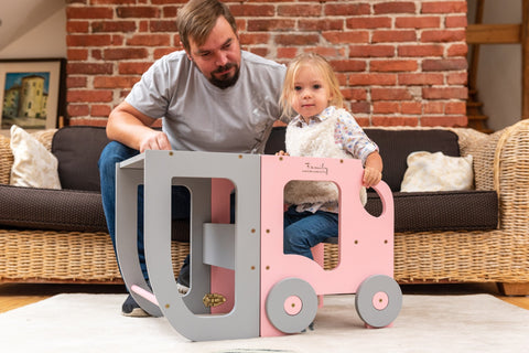 1. Man and child playing with pink and grey Montessori learning table in living room