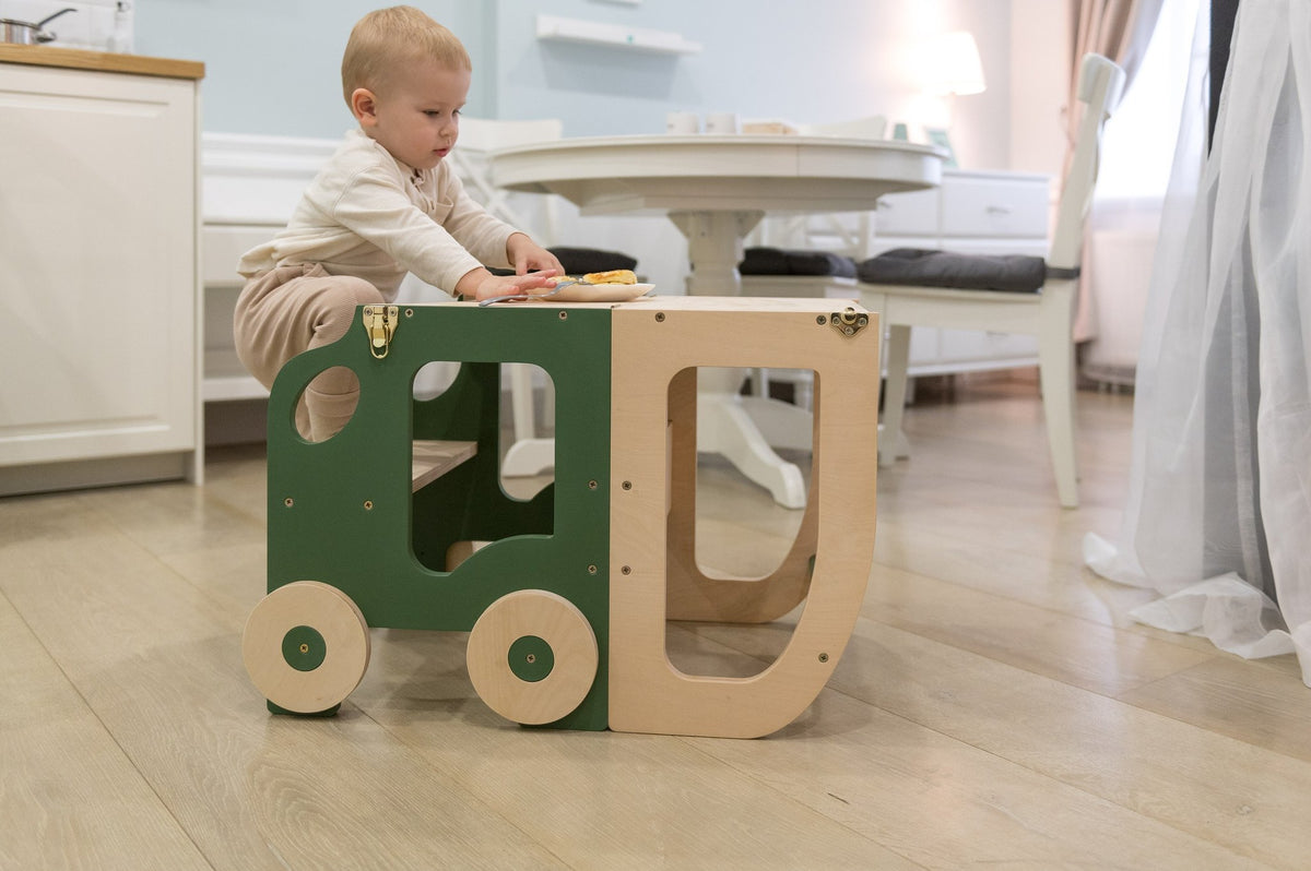 1. Child playing with green and natural wood Montessori learning table in kitchen
