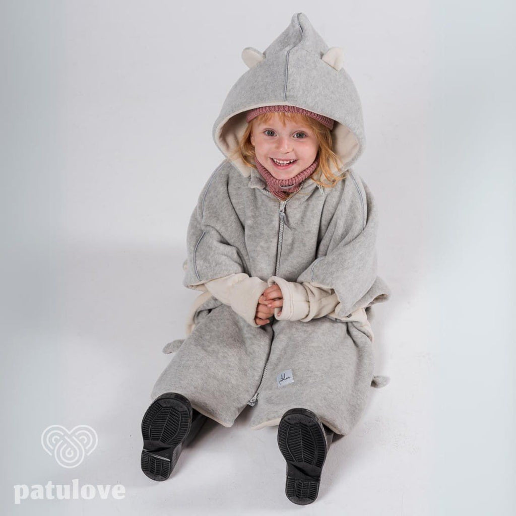 1. Child wearing grey Patulove car poncho with bear ears, sitting and smiling in studio setting