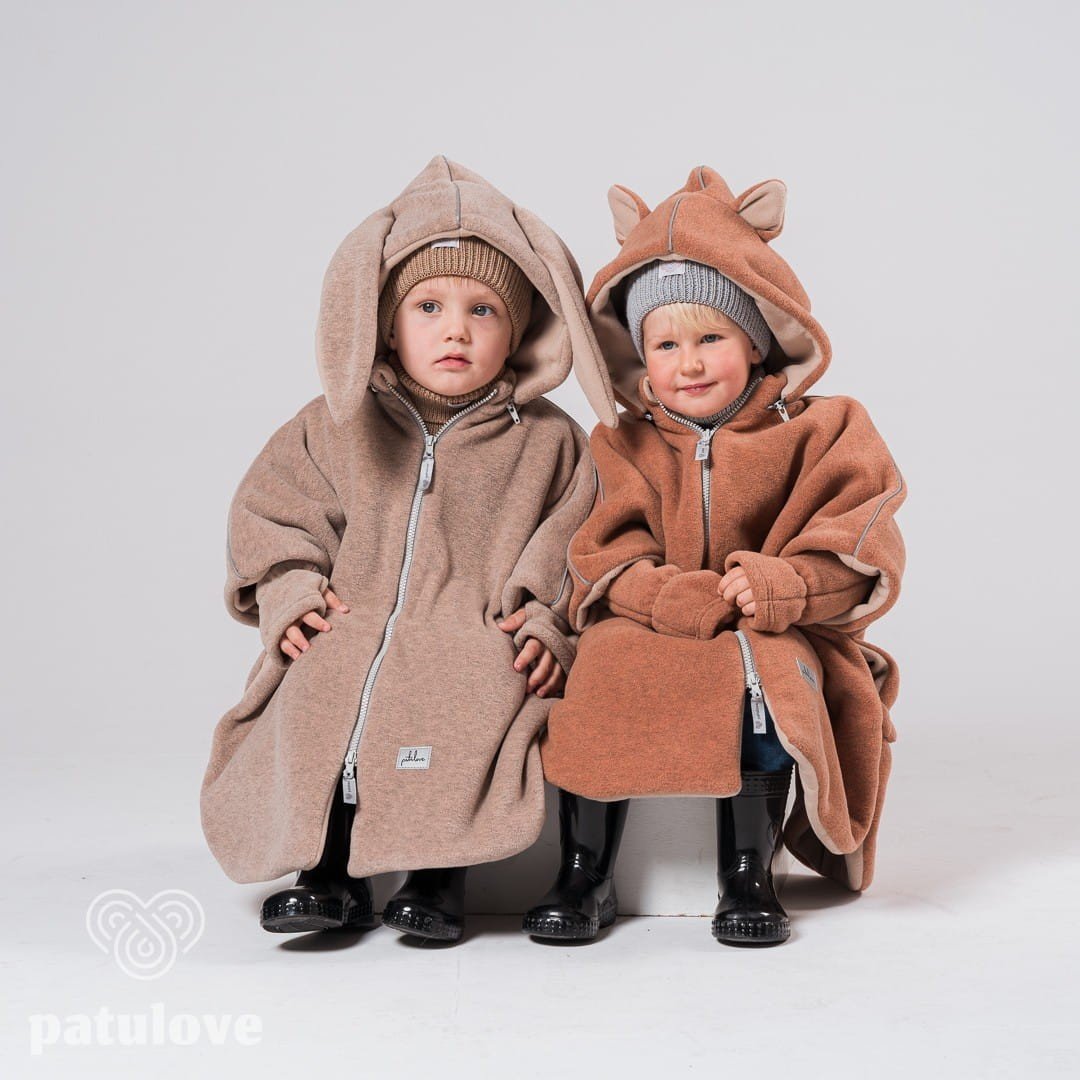 6. Two children sitting in Patulove car ponchos, one beige bunny and one brown with ears, in studio