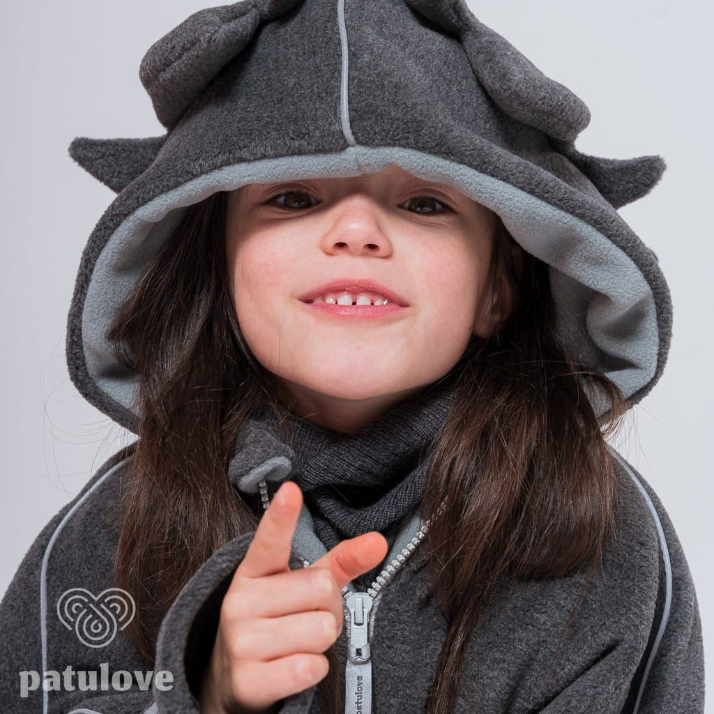 5. Close-up of girl wearing Patulove dragon-themed car poncho with hood, smiling in studio setting