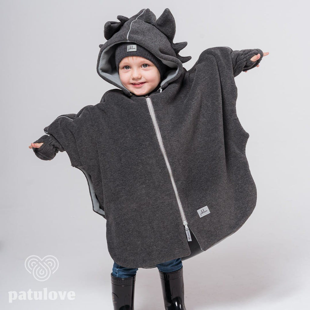 1. Child wearing Patulove dragon-themed car poncho with hood and spikes, standing with arms outstretched in studio setting