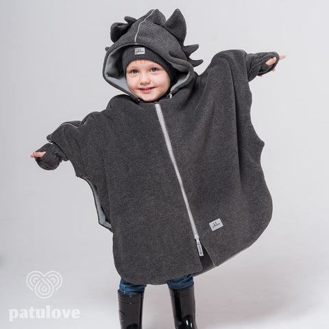1. Child wearing Patulove dragon-themed car poncho with hood and spikes, standing with arms outstretched in studio setting