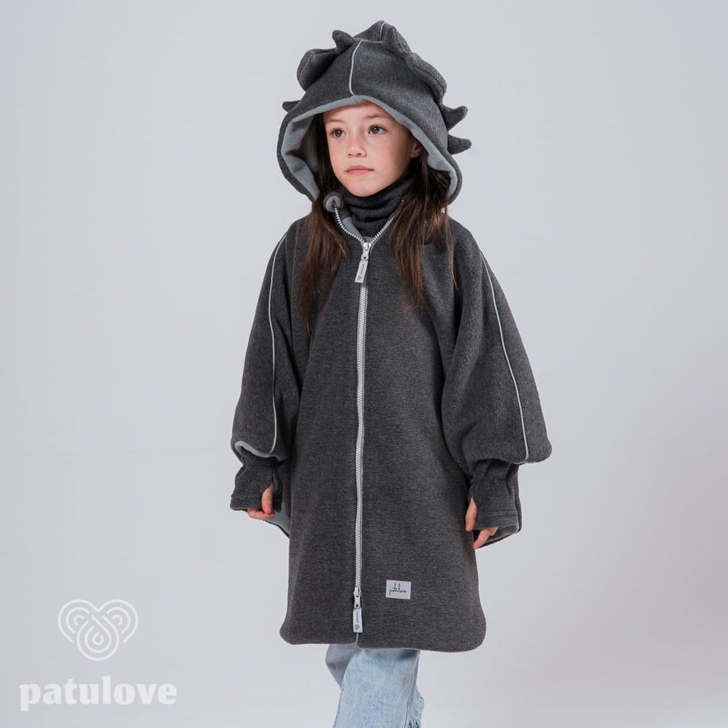 7. Girl wearing Patulove dragon-themed car poncho with hood, standing with hands in pockets in studio setting