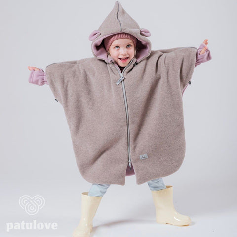 1. Child wearing Patulove pink lamb car poncho with hood and yellow boots, arms outstretched in studio setting