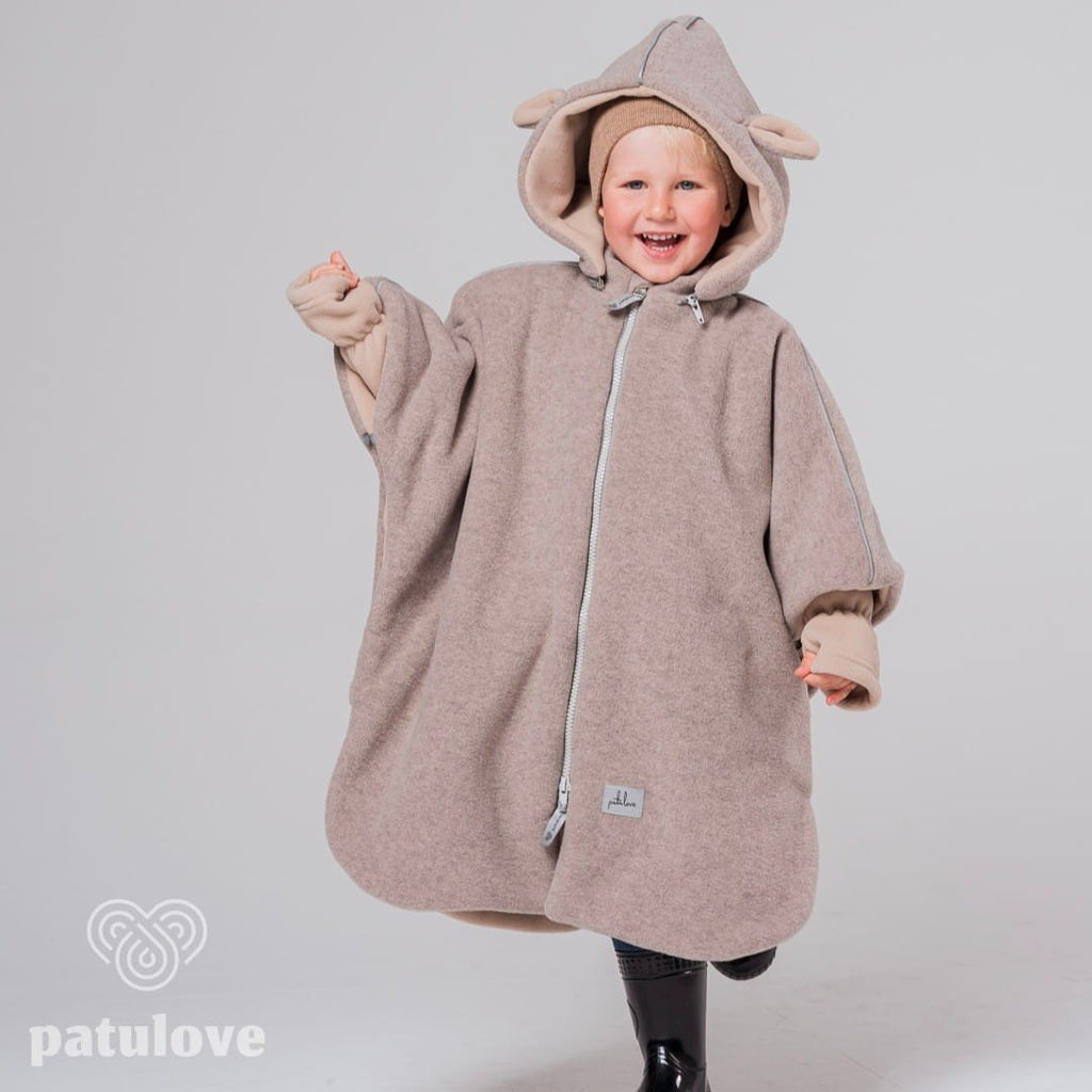 1. Child wearing Patulove lamb beige car poncho with hood, smiling and posing in studio