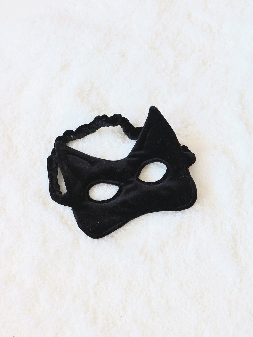 12. Black velvet cat mask with elastic band on a soft white surface